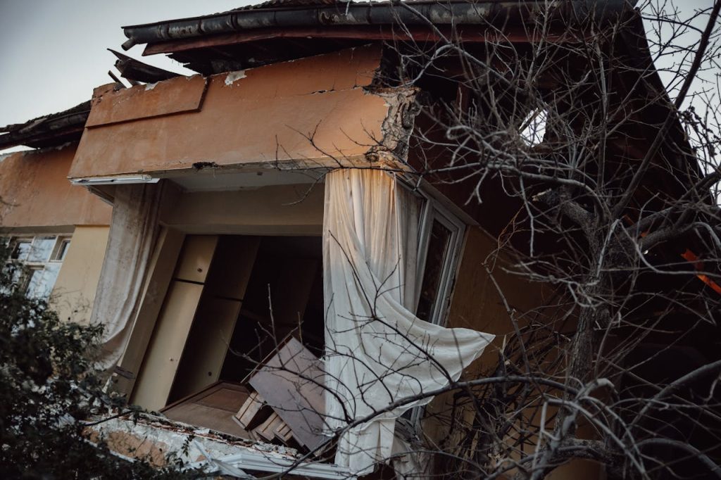 house-destroyed-by-earthquake-16105712 Exterior of a damaged house showing destruction from a natural disaster.