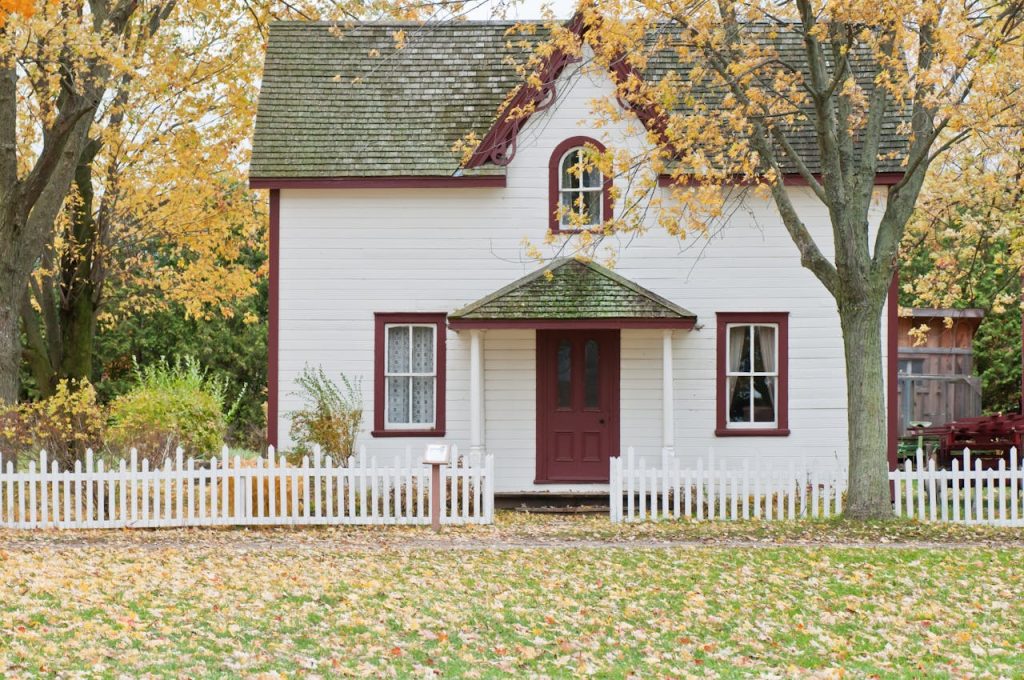 white-and-red-wooden-house-with-fence-1029599 Picturesque traditional house with autumn foliage and a white picket fence in London, Ontario.